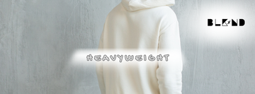 "heavyweight" typed across a cream hoodie. BLKxND logo in black in the upper right corner