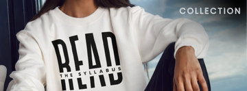 Woman wearing a white Read the Syllabus crewneck sweatshirt and black jeans. the background is light blue with clouds. the word "collection" is in the upper right corner
